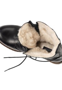 Bota de tobillo de cuero negro con un suave forro de lana color crema. Presenta cordones planos y suela marrón con acentos de costura.