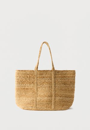 Sac cabas rectangulaire en paille tressée avec deux anses tressées, couleur naturelle noisette, motif texturé sur fond uni clair.