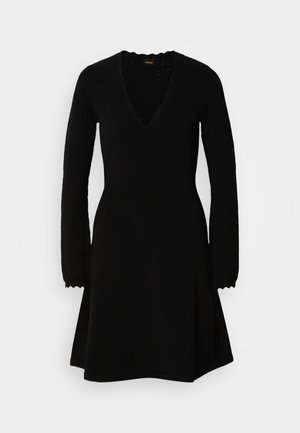 Schwarzes Strickkleid mit V-Ausschnitt, langen gemusterten Ärmeln und ausgestelltem Rock. Texturierte Details sorgen für visuelles Interesse.