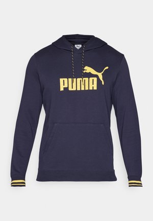 Jūrinės mėlynos spalvos džemperis su kišenėle priekyje, pagamintas iš medvilnės mišinio. Savybės: geltona "PUMA" logotipas ir akcentai ant rankovių. Su reguliuojamu kapučinu.