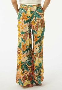 Pantalons larges à motifs floraux avec un mélange de couleurs orange, jaune et vert. Dotés d'une taille élastique et d'un tissu léger et fluide.
