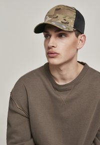 Camo baseballcap met een ronde rand, gemaakt van stof en gaas, in aardetinten van bruin en groen, met een aansluitend ontwerp.