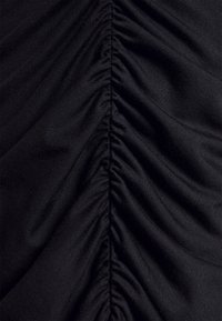 Tissu noir avec fronces horizontales, présentant une texture lisse et un tombé souple. Comprend des plis uniformément espacés pour un détail structuré.