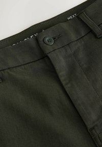 Dark green fabric trousers featuring a button closure, flat front design, and neatly stitched seams. Material appears smooth with slight texture.