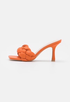 Sandales à talons orange avec un dessus tressé rembourré. Style à bout ouvert doté d'un talon aiguille élégant et d'un matériau synthétique lisse.