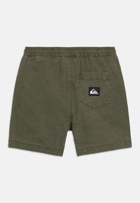 Λαδί κοντό παντελόνι ανδρικό με ελαστική μέση και μια πίσω τσέπη με μαύρο λογότυπο σε απλό φόντο.