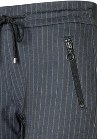 Dunkelblaue gestreifte Jogginghosen mit verstellbarem Bund, einem seitlichen Reißverschlusstaschen und einem strukturierten, weichen Stoff.