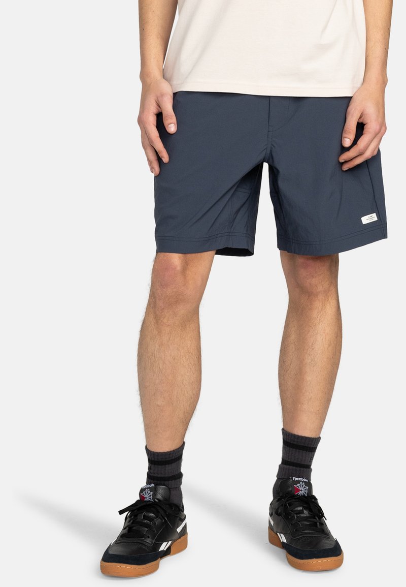 Mörkblå shorts i lätt material, med dragsko i midjan, sidofickor och en liten logopatch på underbenet.