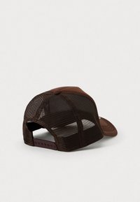 Căciulă trucker din plasă maro, cu închidere ajustabilă prin sistem snapback, arătând panourile din spate și laterale pe un fundal deschis.