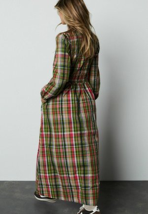 Maxikleid mit grünem, rotem und weißem Karomuster, langen Ärmeln und einem gerafften Taillendesign. Der Stoff wirkt leicht.