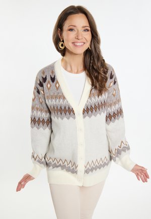 Cardigan grigio chiaro con motivi geometrici marroni e beige, scollo a V, apertura con bottoni e polsini a costina. Texture morbida e vestibilità ampia.