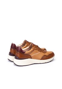 Zapatillas de cuero marrón con talón de un marrón oscuro en contraste. Presentan una suela blanca, cordones redondos y costuras decorativas a lo largo de los lados.