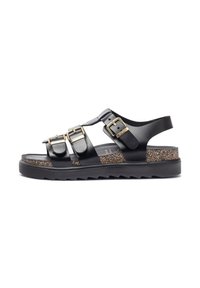 Zwarte leren sandalen met drie gespbandjes, een gestructureerde kurken voetbed en een rubberen zool met een zigzagprofiel.