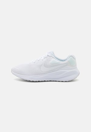 Zapatilla deportiva blanca con parte superior de malla, cierre de cordones, suela acolchada y un discreto logotipo de la marca en el lateral, mostrada en vista lateral.