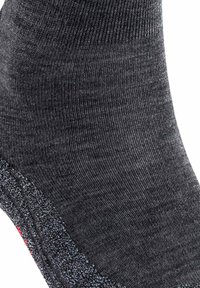 Calcetín de tobillo gris con un tejido texturizado, que presenta un talón y una punta de color contrastante. Tejido suave con ligera elasticidad.