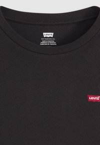 Zwarte katoenen T-shirt met een ronde halslijn, voorzien van een klein rood Levi's-logo aan de linkerkant. De stof heeft een gladde, uniforme textuur.