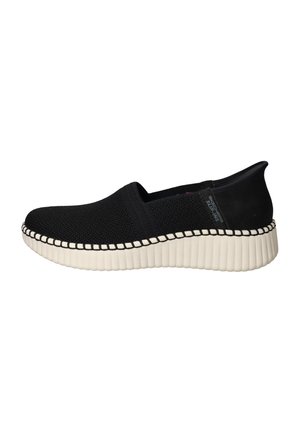 Black slip-on shoe with a textured knit upper, white ribbed sole, and contrasting stitch detailing along the edge.