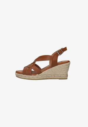 Brown leather wedge sandal with a braided front strap and adjustable ankle buckle. Tapered woven jute sole adds texture and height.