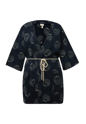 Navy kimono-tyylinen viitta, jossa on valkoinen simpukkakuvio, lyhyet hihat, V-pääntie ja beige vyö vyötäröllä.