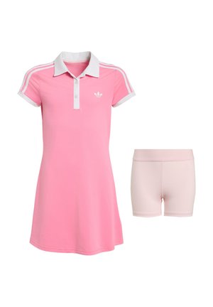 Robe polo rose à manches courtes avec col blanc et rayures, associée à un short ajusté rose clair sur fond blanc.