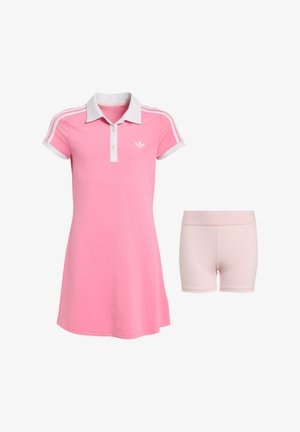 Vestido polo rosa de manga corta con cuello blanco y rayas, combinado con pantalones cortos ajustados en rosa claro sobre fondo blanco.