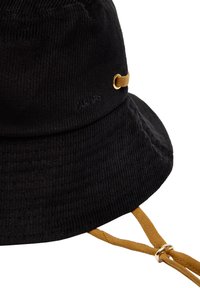 Czarny kapelusz typu bucket z korduroju o miękkiej strukturze, z beżowym paskiem i złotymi detalami, zaprojektowany w kształcie szerokiego, opadającego rondka.