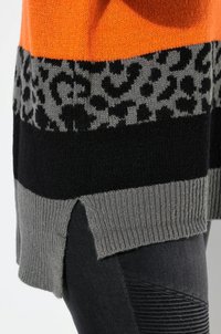 Strickpullover mit orange, grau und schwarzen Streifen; grauem Leopardenmuster; seitlichen Schlitzen am Saum; geripptem Textur am unteren Ende.