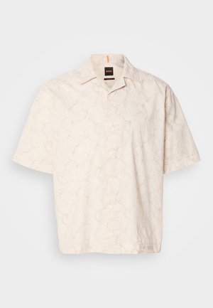 Camisa de manga curta, com botões, na cor bege clara com um padrão de mármore sutil, feita de tecido suave, apresentando um colarinho clássico e etiqueta no peito.