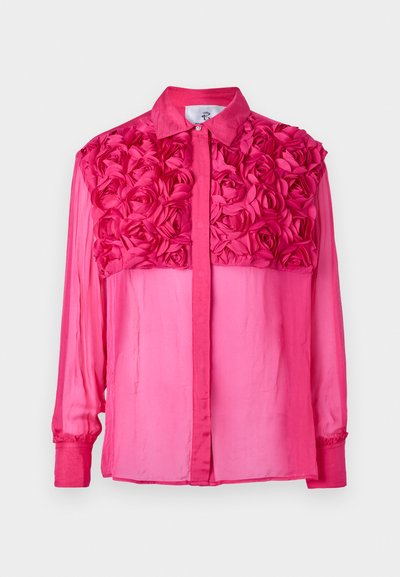 Chemise rose à boutons avec un design floral texturé sur les épaules, à manches longues et en tissu lisse et léger tout au long.
