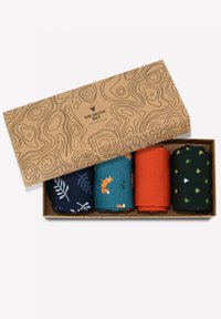 Conjunto de cuatro pares de calcetines enrollados en una caja. Incluye calcetines azules con diseño de hojas, teal con zorros, naranjas y verdes con patrones de árboles. La caja tiene un diseño topográfico.