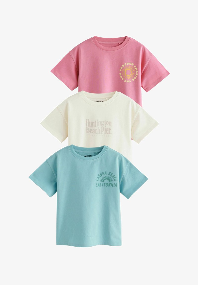 Drei gefaltete T-Shirts mit kurzen Ärmeln in Pink, Weiß und Hellblau mit strandbezogenem Text und Sonnen-Grafik auf der linken Brust.