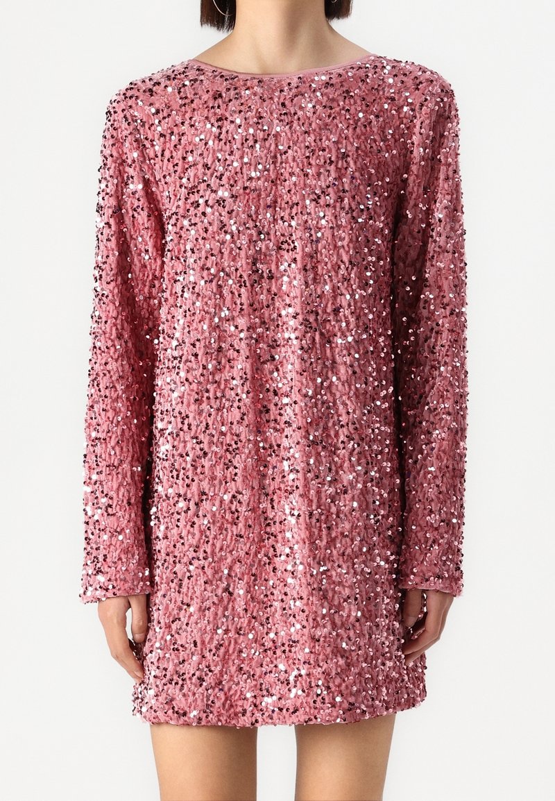 Robe rose à sequins avec manches longues, présentant une coupe ample et un col rond. La texture est brillante et réfléchissante, mettant en valeur le design global.