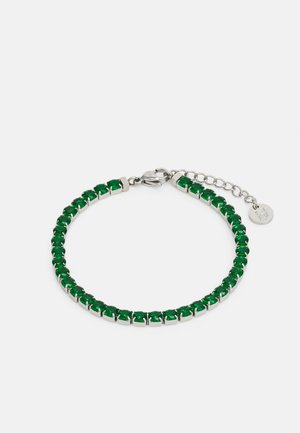 Zielona kryształowa bransoletka z metalowymi elementami w kolorze srebrnym. Zawiera przedłużacz łańcuszka umożliwiający regulację długości oraz zapięcie typu homar zapewniające bezpieczne zapięcie.