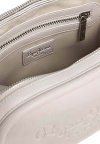 Borsa sintetica grigia con interno foderato, chiusura con zip e etichetta dell'azienda. Presenta una superficie testurizzata e doppie tasche con zip.