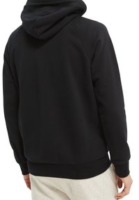 Sort hættetrøje med en afslappet pasform, ribbet kant og manchetter samt raglanærmer. Stoffet virker blødt og tekstureret.