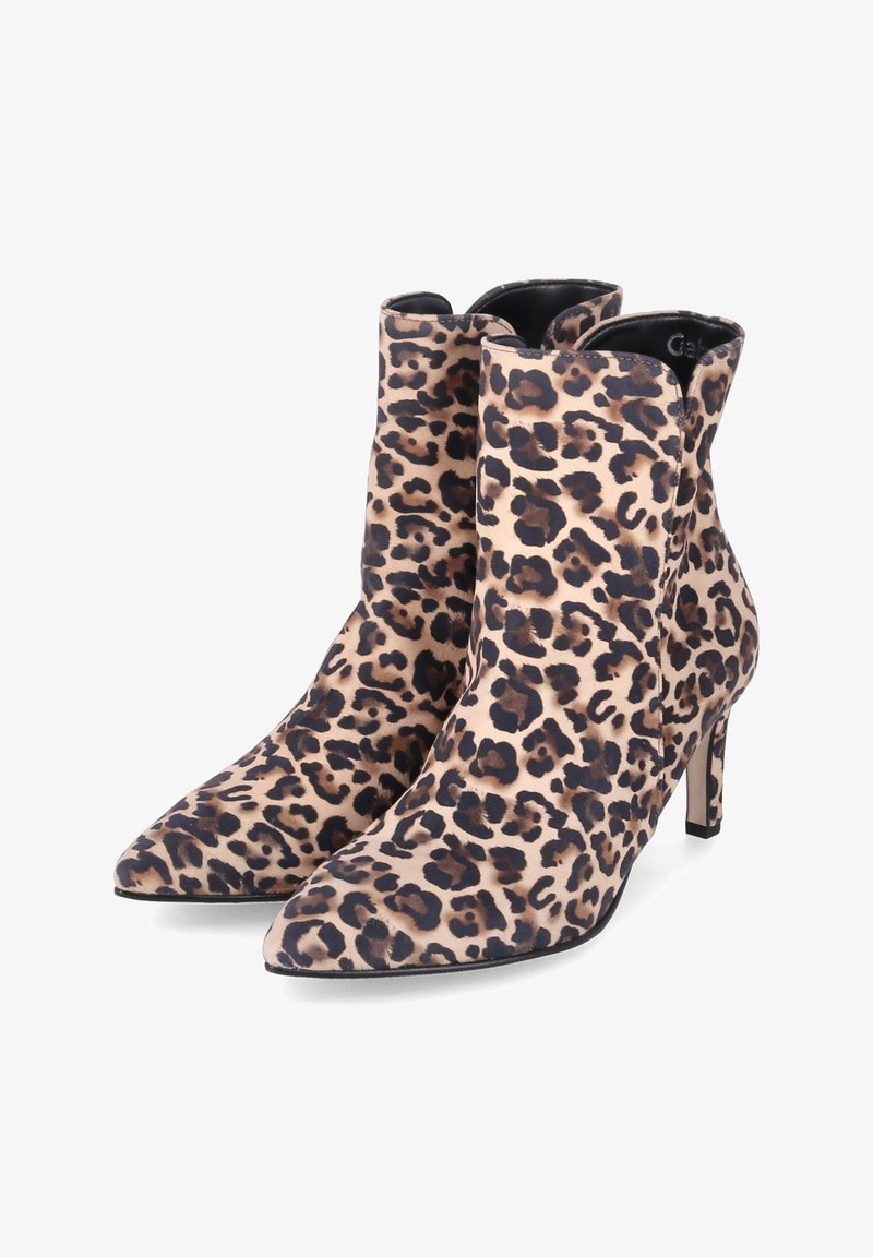 Paire de bottines à bout pointu avec motif léopard et talons hauts fins sur fond blanc.