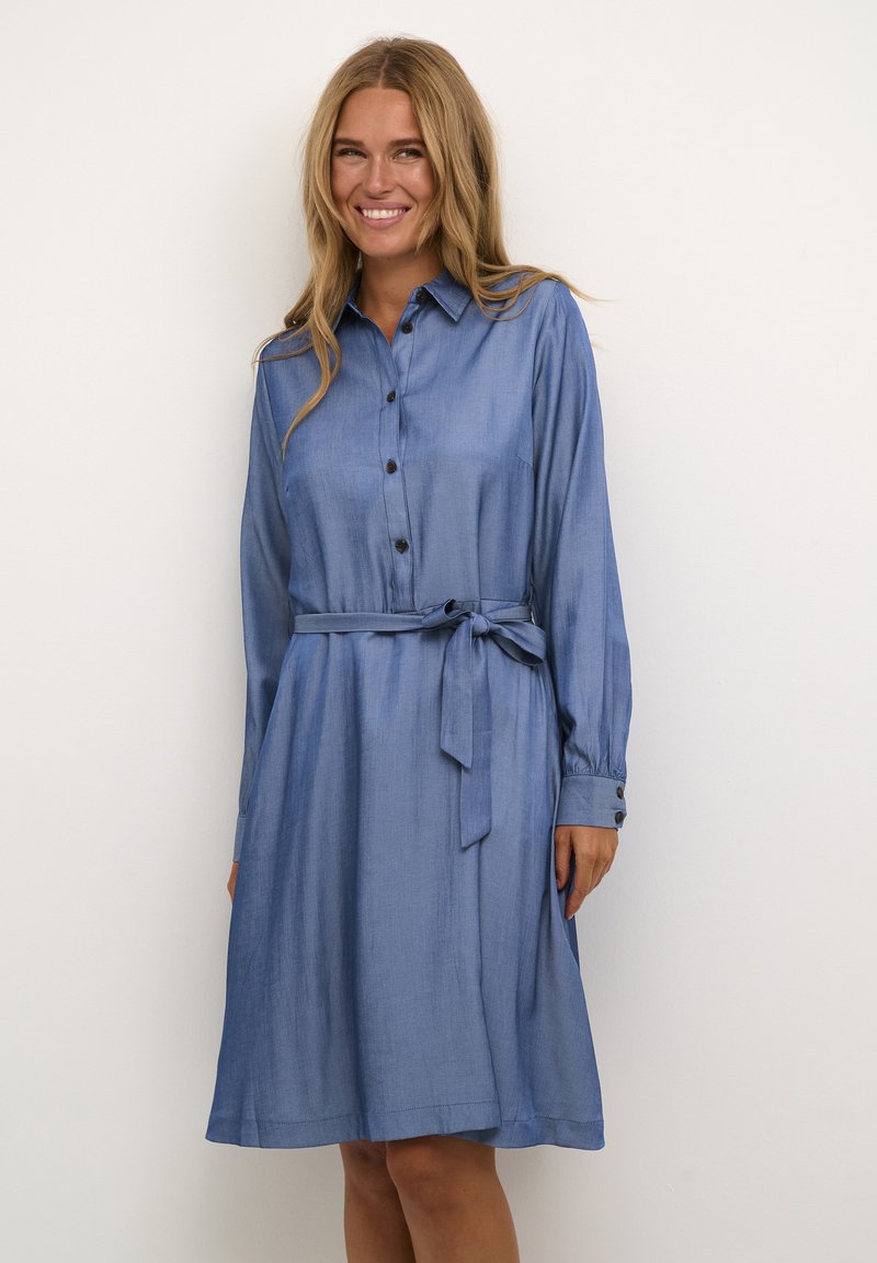 Bla dresses mit langen Ärmeln, geknöpftem Kragen, gebundenem Taillengürtel, weichem Material und lockerer Passform. Verfügt über geknöpfte Manschetten und einen ausgestellten Rock.