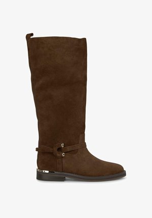 Botte marron en suede à hauteur de genou avec une texture lisse, un bout arrondi et une sangle décorative avec des accents métalliques à la cheville.