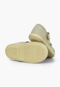 Beige espadrilles dengan atas kain bermotif tekstur, sol bermotif jute, dan strap velcro. Sol karet datar dengan pola beralur.