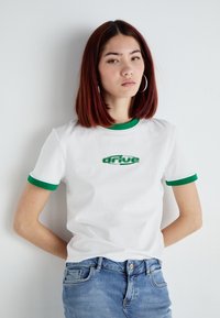 Hvit bomull T-skjorte med grønn ribbestrikket krage og mansjetter, brodert "drive" logo i grønn, korte ermer og avslappet passform.