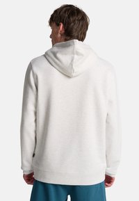 Weißer Fleece-Hoodie mit einer Zugkordelkapuze, gerippten Bündchen und Saum. Weicher Stoff, Rückansicht zeigt minimalistisches Design.