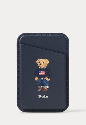 Mørkeblå læder kortholder med lomme, med en bamse iført en trøje med det amerikanske flag og teksten "Polo" nedenunder.