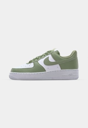 Nike Air Force 1-sneakers i grønt og hvitt lær. Lave sko, rund tå, teksturert gummisåle, og fremtredende swoosh-logo detaljer.