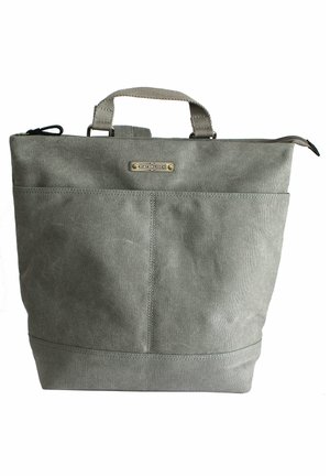 Gray canvas tote bag with top handles, a front pocket, and an embossed metal logo plate. Smooth texture and structured shape.
