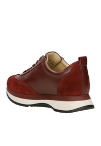 Baskets bordeaux en cuir lisse et en daim, avec un intérieur beige rembourré, une semelle intermédiaire blanche et une semelle extérieure en caoutchouc noir, inclinées pour montrer l'arrière et le côté.