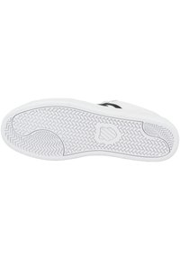 Vit sneakersula med texturerat gummi för grepp, med ett fiskbensmönster och en logotyp i mitten.