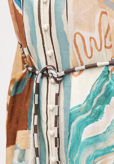 Λεπτομέρεια φορέματος με αφηρημένο πολύχρωμο σχέδιο σε τιρκουάζ, καφέ και μπεζ, με κουμπιά καλυμμένα με ύφασμα και δεμένη ριγωτή ζώνη από ύφασμα στη μέση.