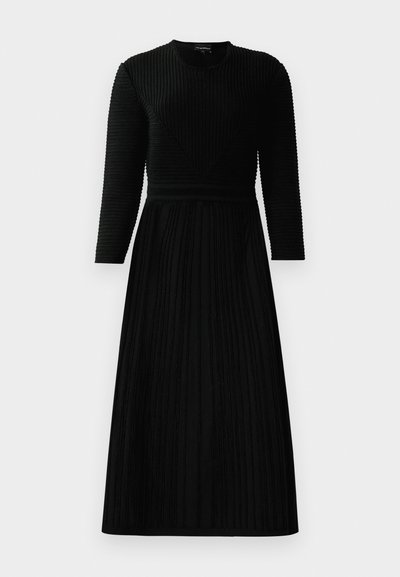 Vestido preto de manga longa com acabamento texturizado em nervuras, apresentando um corpete ajustado e uma saia rodada. Decote redondo e detalhes em padrão de riscas verticais.