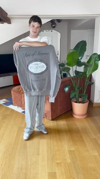 Felpa grigia con testo "Scent of Summer" e logo "PEGADOR". Tessuto morbido, maniche lunghe, vestibilità rilassata, abbinata a pantaloni a righe grigie chiare.