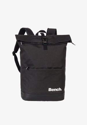 Sac à dos en tissu noir avec une conception à rabat, des bretelles réglables, une poche avant et un panneau inférieur noir mat arborant un logo.